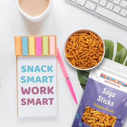 Soya Sticks in Chatpata Masala flavor placed on a desk alongside a notebook with colorful sticky notes, a pen, and a bowl of snacks, promoting the tagline 'Snack Smart, Work Smart.